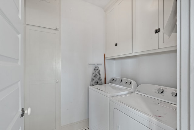 clothes washing area with washer and dryer and cabinets