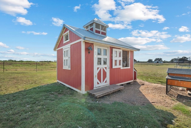 view of outbuilding featuring a yard and a rural view