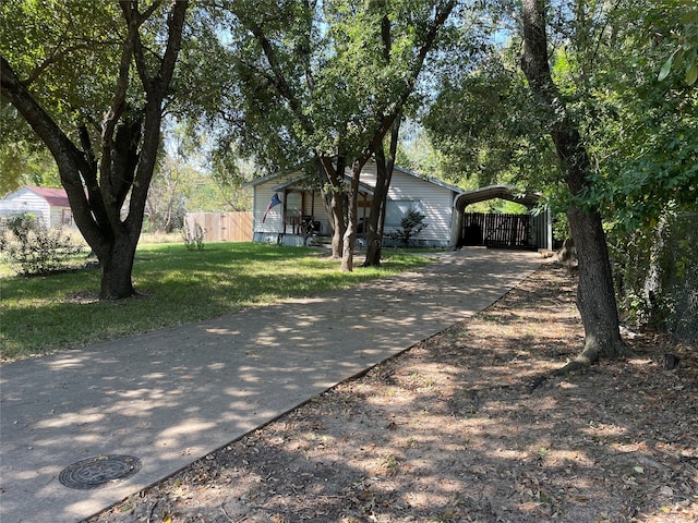 ranch-style home featuring a front lawn and a carport