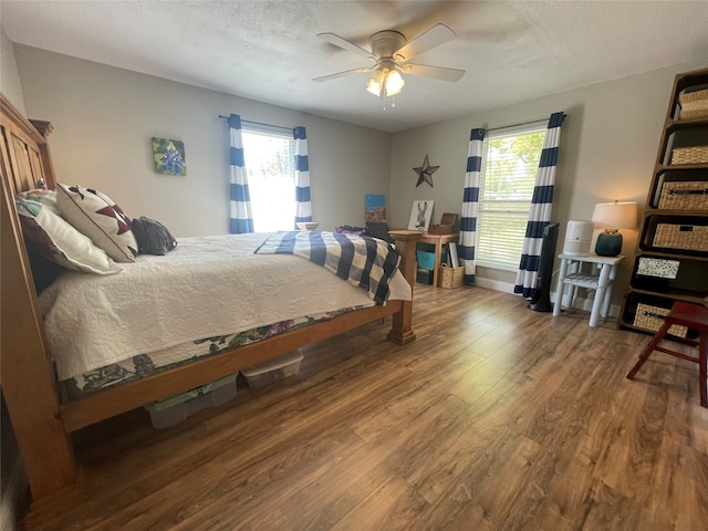 bedroom featuring wood-type flooring, a textured ceiling, and ceiling fan