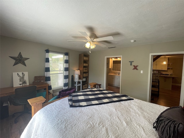 bedroom with a spacious closet, a textured ceiling, dark hardwood / wood-style flooring, a closet, and ceiling fan