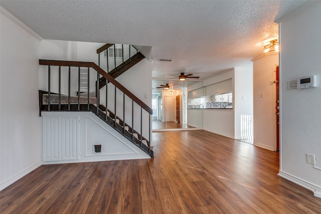 interior space featuring ceiling fan, crown molding, a textured ceiling, and hardwood / wood-style floors