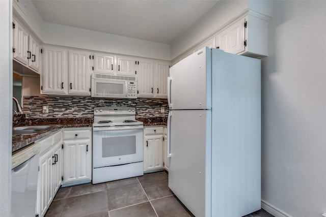 kitchen featuring backsplash, dark tile patterned flooring, sink, white appliances, and white cabinetry