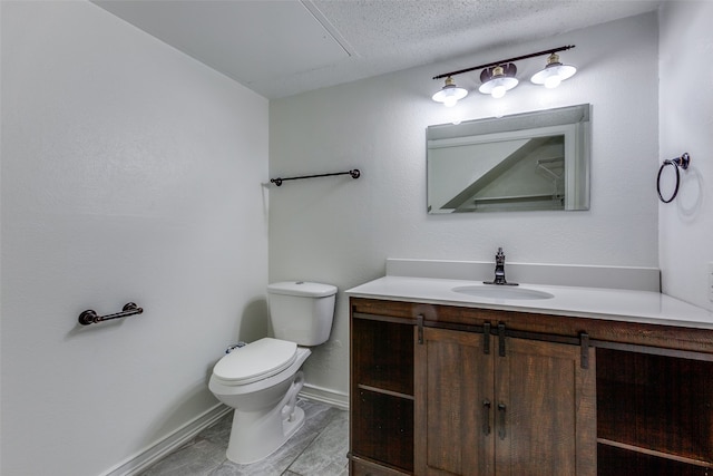 bathroom featuring toilet, vanity, and a textured ceiling