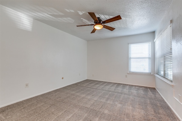 carpeted empty room with ceiling fan and a textured ceiling