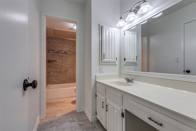 bathroom with tiled shower / bath combo and vanity