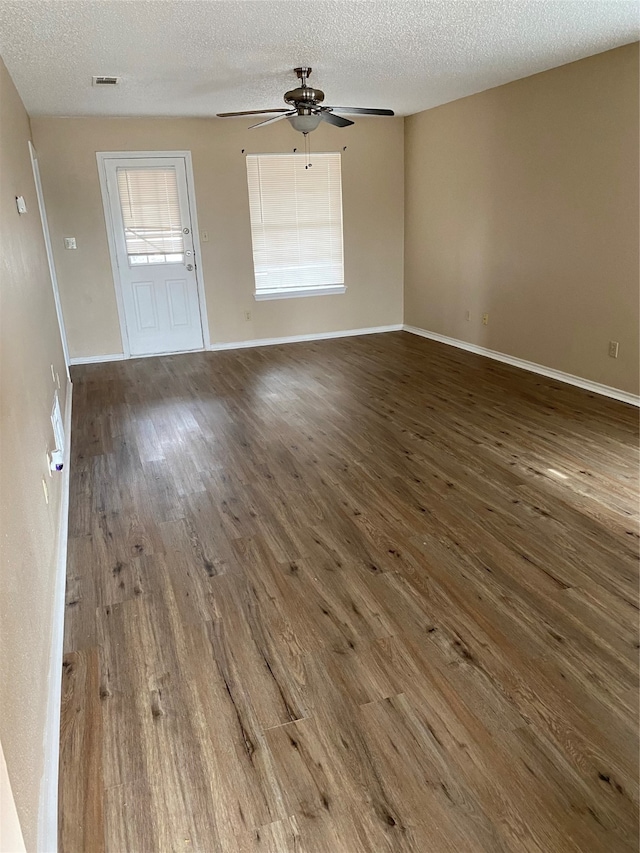 spare room with ceiling fan, a textured ceiling, and dark hardwood / wood-style floors