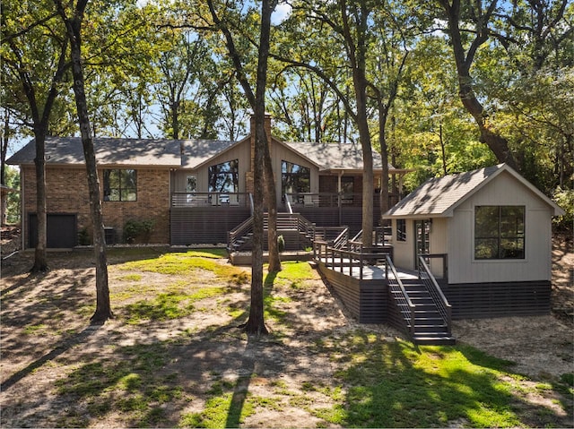 rear view of house with an outbuilding and a wooden deck