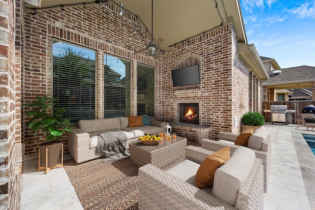 view of patio with an outdoor living space with a fireplace, ceiling fan, and a grill