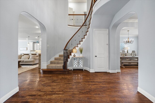 entrance foyer featuring crown molding, dark hardwood / wood-style flooring, and an inviting chandelier