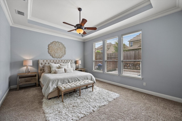 bedroom with carpet flooring, a raised ceiling, ceiling fan, and crown molding