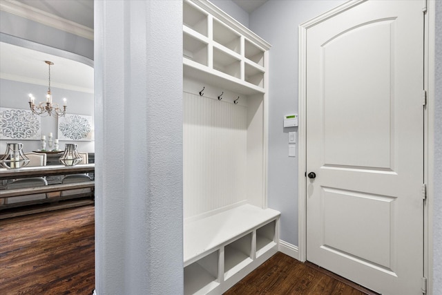 mudroom with dark hardwood / wood-style flooring, an inviting chandelier, and crown molding