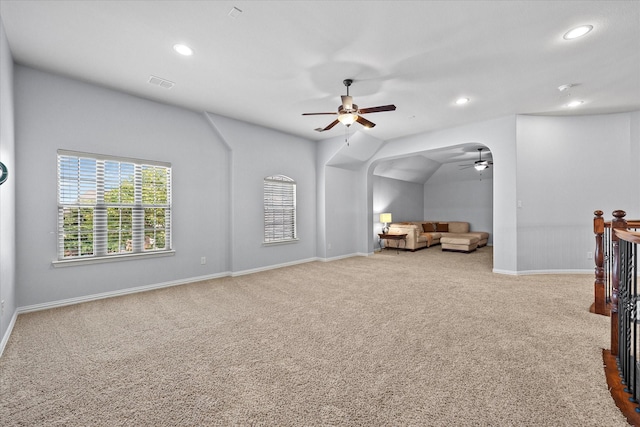 interior space with ceiling fan, light colored carpet, and lofted ceiling