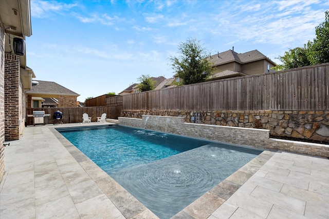 view of swimming pool with grilling area, pool water feature, and a patio