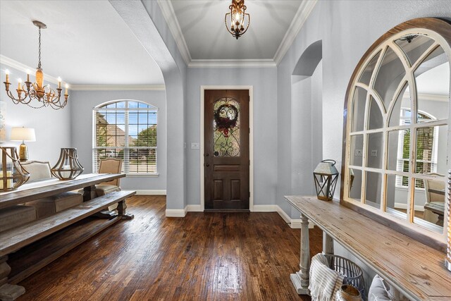 entryway featuring crown molding, dark wood-type flooring, and an inviting chandelier