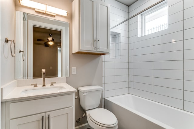 full bathroom featuring ceiling fan, tiled shower / bath, vanity, and toilet