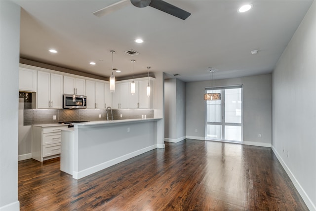 kitchen featuring dark wood-type flooring, decorative light fixtures, and white cabinetry