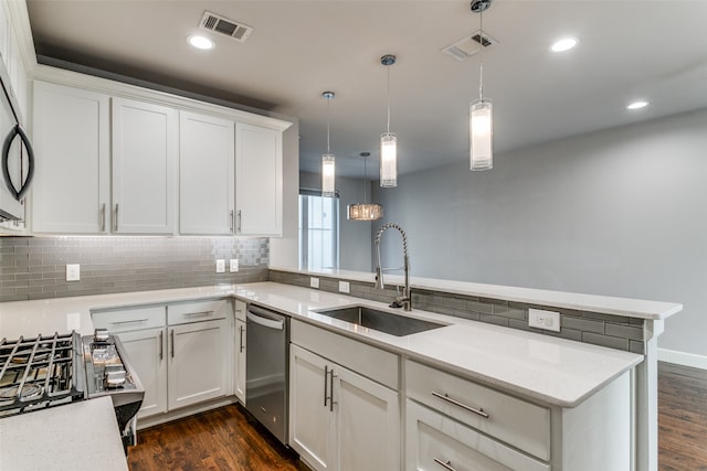 kitchen featuring sink, kitchen peninsula, pendant lighting, white cabinetry, and appliances with stainless steel finishes