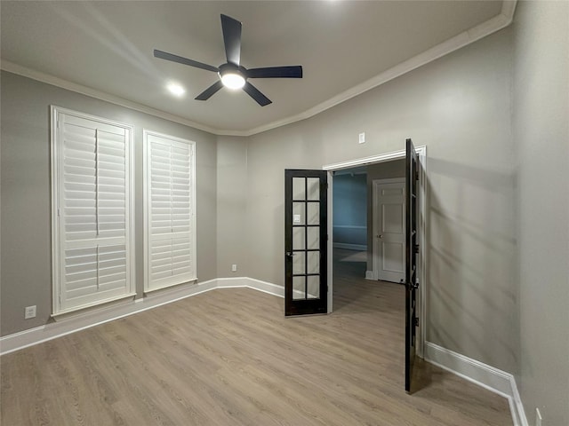 spare room featuring baseboards, ornamental molding, wood finished floors, and french doors