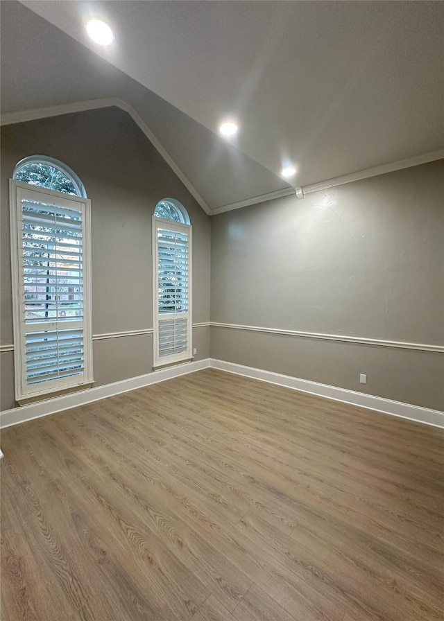 spare room with ornamental molding, hardwood / wood-style floors, and lofted ceiling