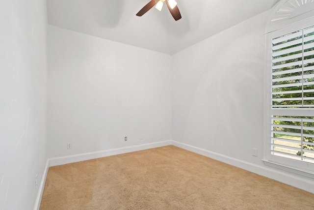 carpeted empty room featuring ceiling fan and baseboards