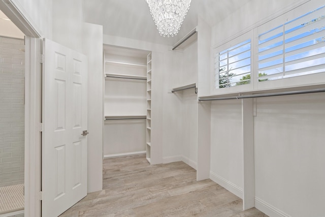 walk in closet featuring a chandelier and wood finished floors