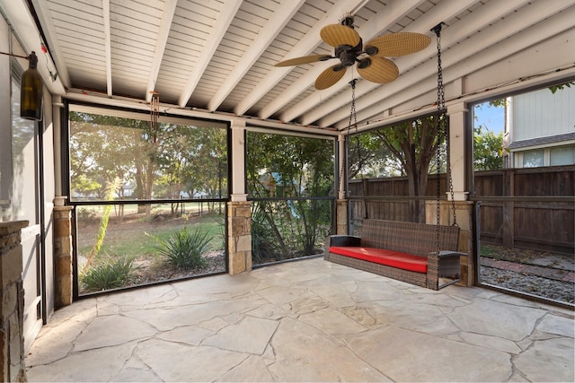 unfurnished sunroom featuring a ceiling fan