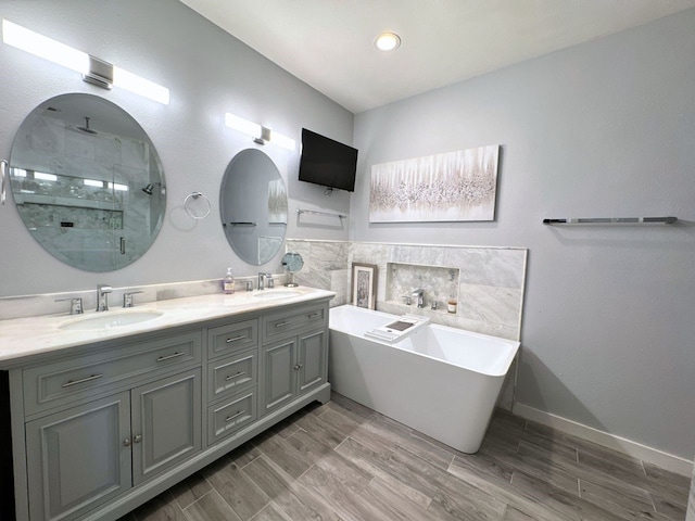 bathroom featuring hardwood / wood-style floors, vanity, and plus walk in shower