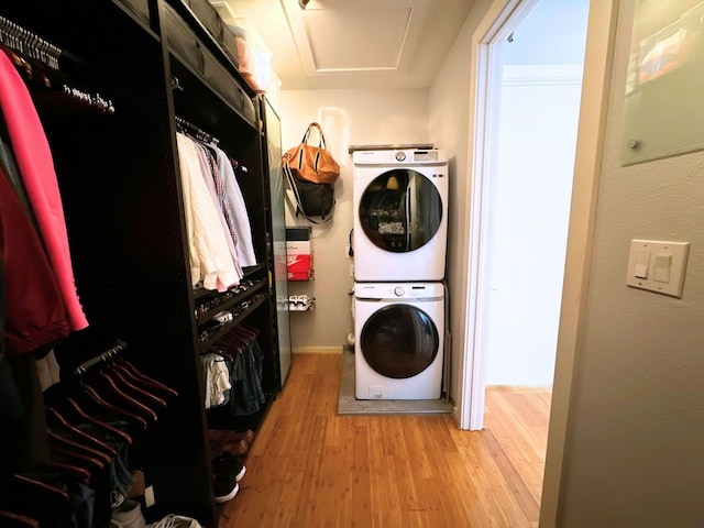 laundry area featuring light hardwood / wood-style flooring and stacked washer / drying machine