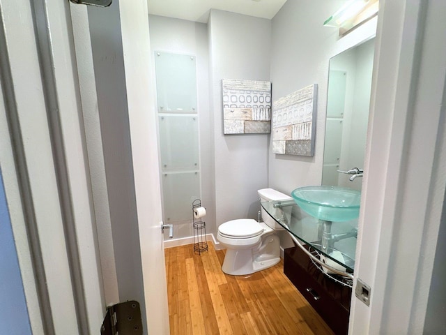 bathroom with hardwood / wood-style flooring, vanity, and toilet