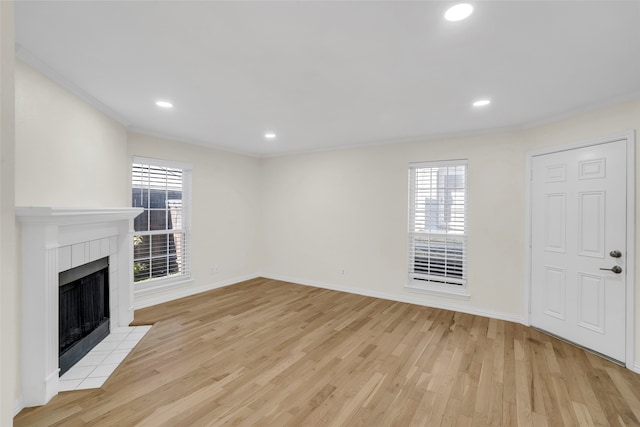 unfurnished living room with a fireplace, light hardwood / wood-style floors, and ornamental molding