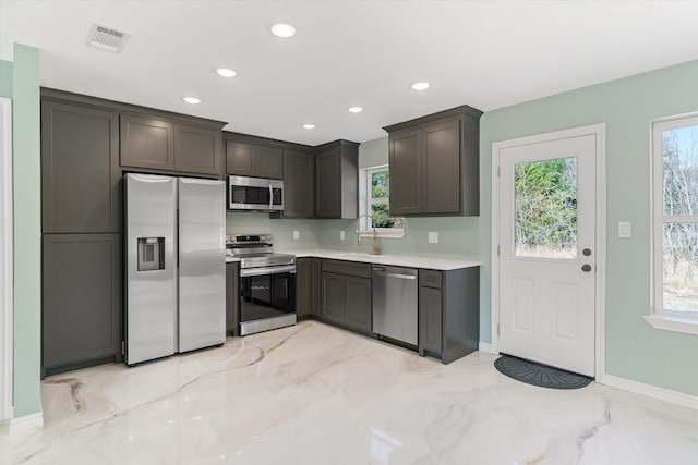 kitchen featuring dark brown cabinets, appliances with stainless steel finishes, sink, and a wealth of natural light