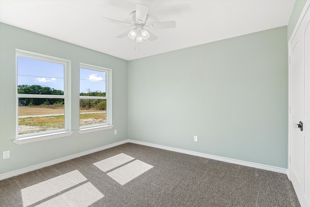 empty room featuring ceiling fan and carpet