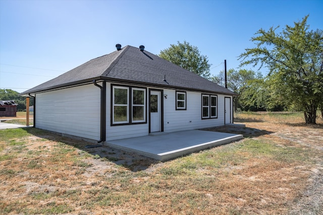 rear view of house with a patio and a lawn