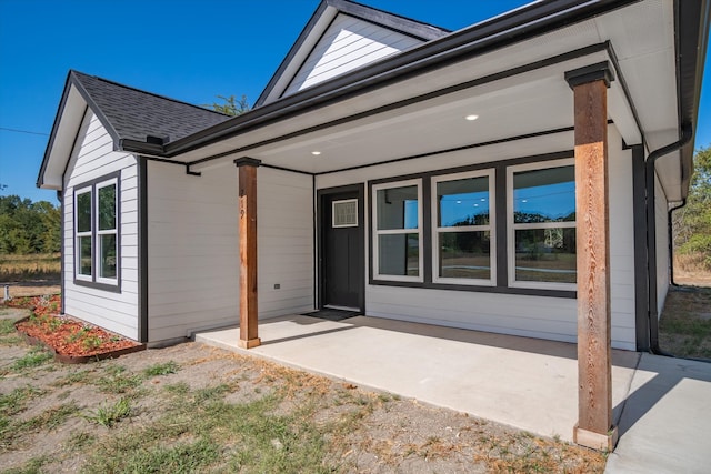 view of exterior entry with a patio area