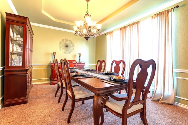 dining area featuring light carpet, a raised ceiling, an inviting chandelier, and ornamental molding