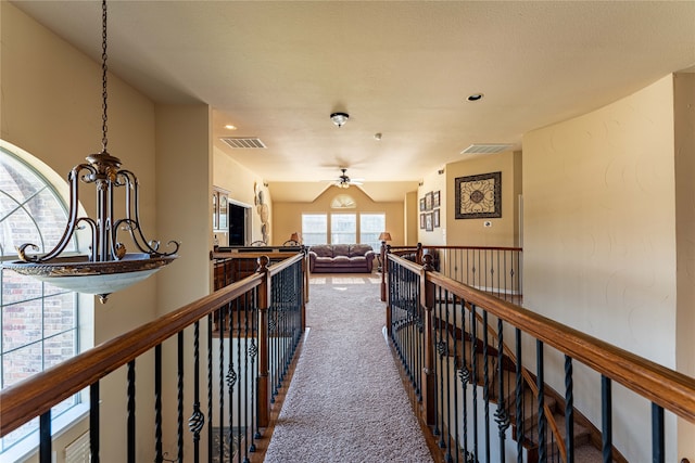 hall featuring carpet and a textured ceiling