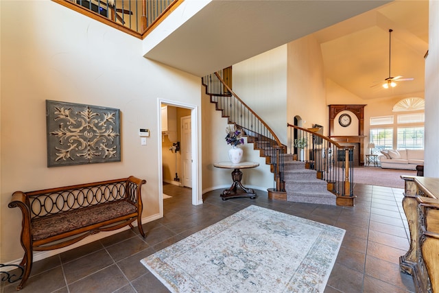 tiled foyer entrance featuring ceiling fan and high vaulted ceiling