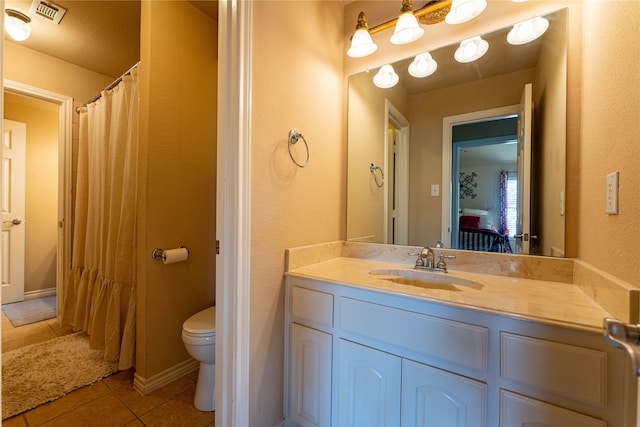 bathroom featuring tile patterned flooring, vanity, and toilet