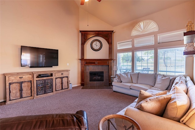 carpeted living room with high vaulted ceiling, ceiling fan, and a tiled fireplace