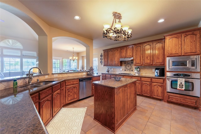 kitchen with pendant lighting, a notable chandelier, a center island, and appliances with stainless steel finishes