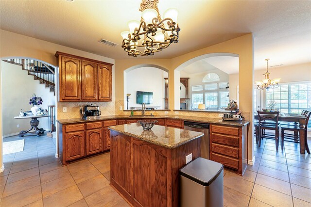 kitchen featuring a center island, an inviting chandelier, tasteful backsplash, decorative light fixtures, and kitchen peninsula