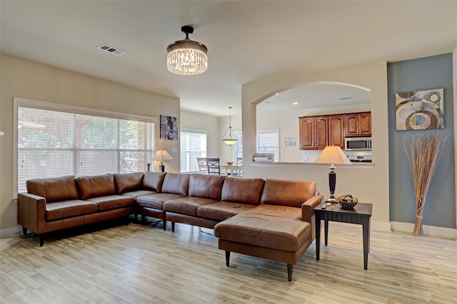 living room featuring an inviting chandelier and light hardwood / wood-style floors