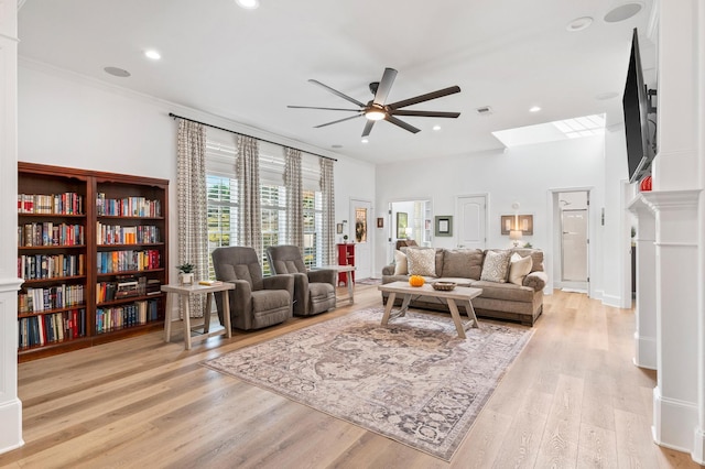 living room with ceiling fan, crown molding, and light hardwood / wood-style floors