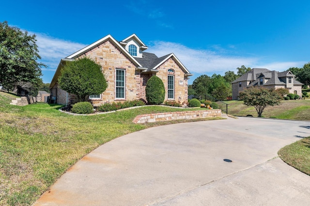 view of front of home with stone siding and a front lawn