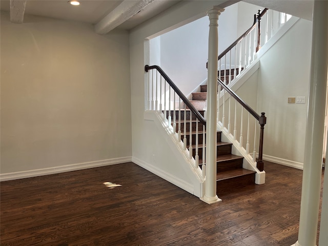 stairs with wood-type flooring and beamed ceiling