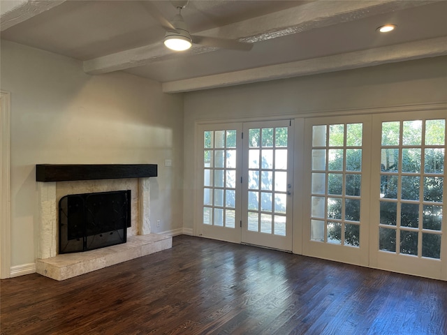 unfurnished living room featuring a wealth of natural light, beamed ceiling, dark wood-type flooring, and a fireplace