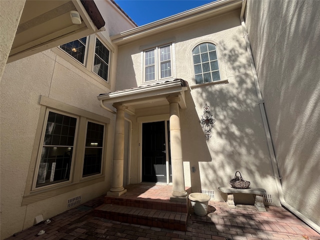 view of exterior entry featuring a patio