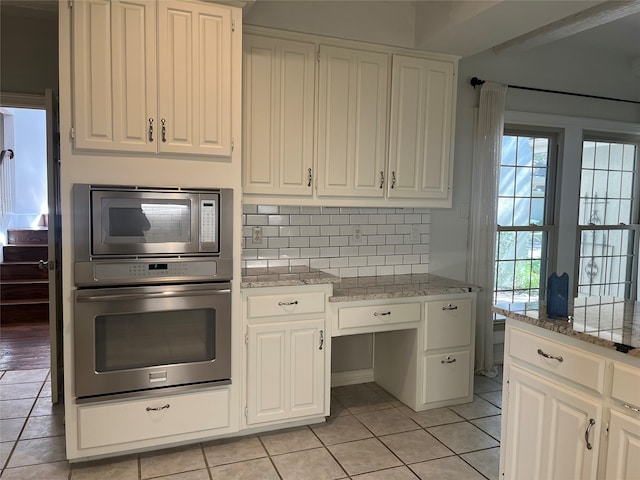 kitchen featuring appliances with stainless steel finishes, white cabinets, and light tile patterned floors