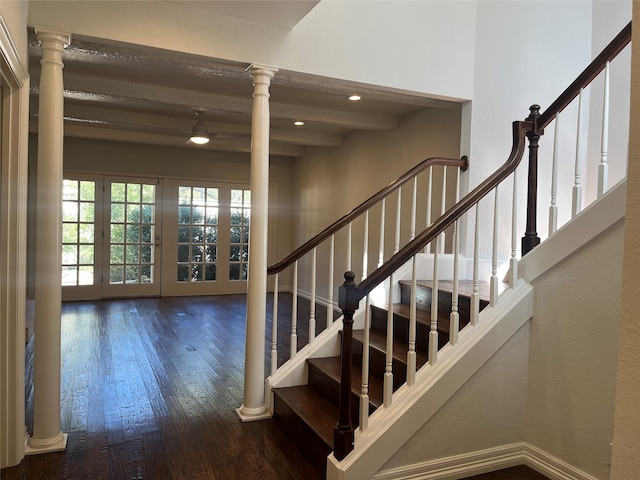 staircase featuring beamed ceiling, french doors, ornate columns, and hardwood / wood-style flooring